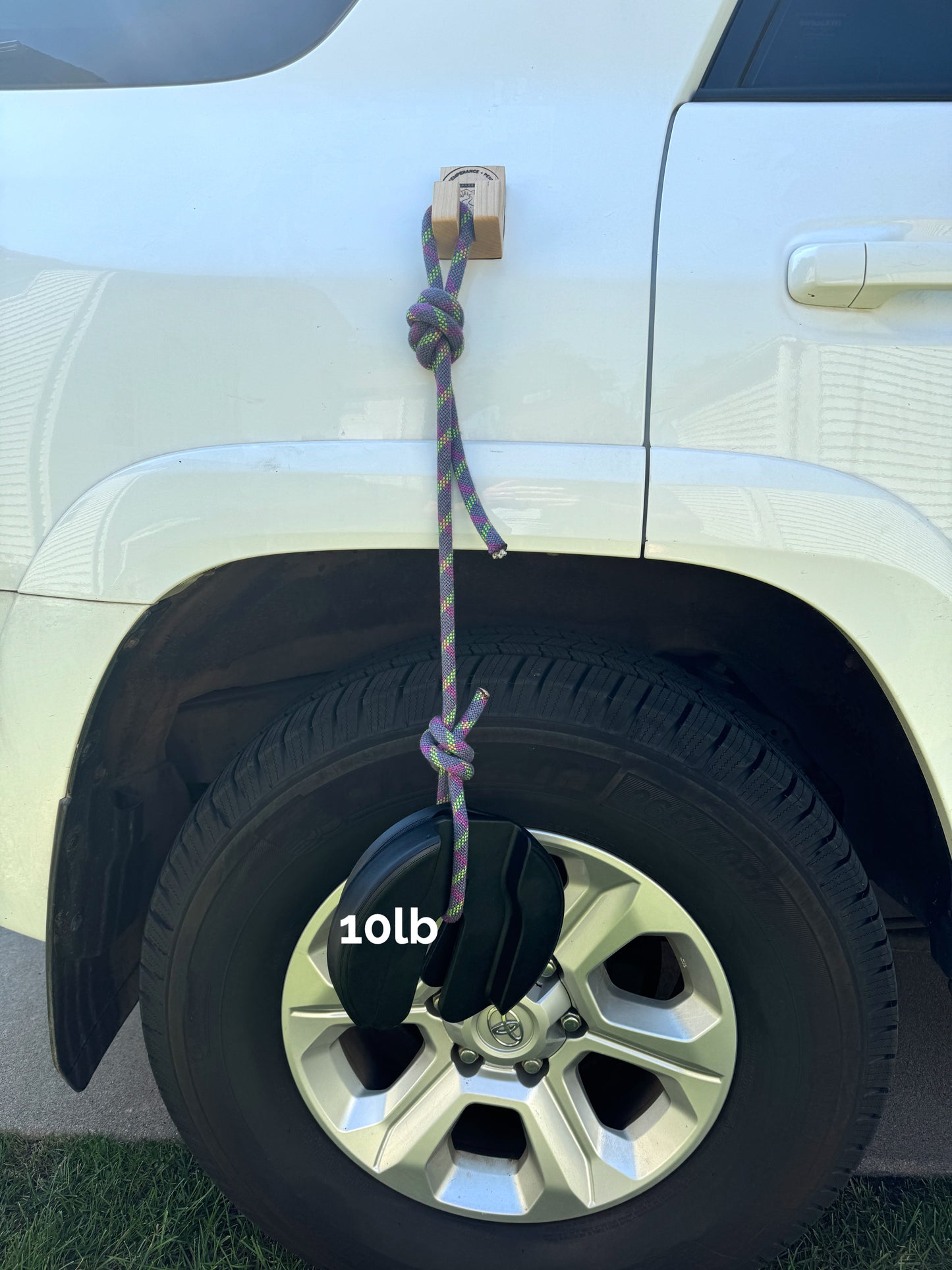 Gearhook on a vehicle with a 10lb weight hanging from it. Illustrating the magnetic strength ideal for anglers, campers, hunters, and outdoor enthusiasts seeking versatile storage solutions.
